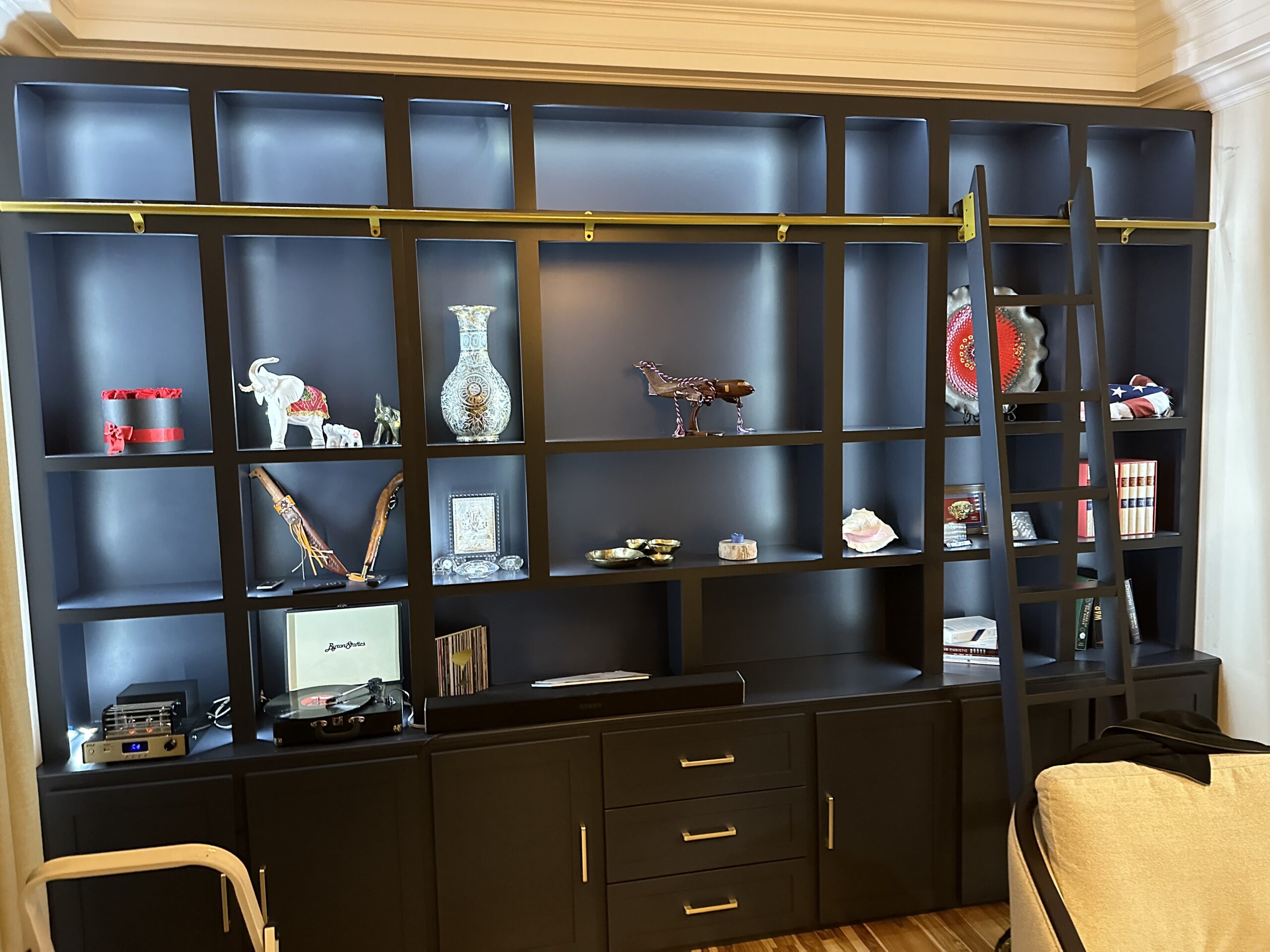 Custom built-in library with gold accents and rolling ladder