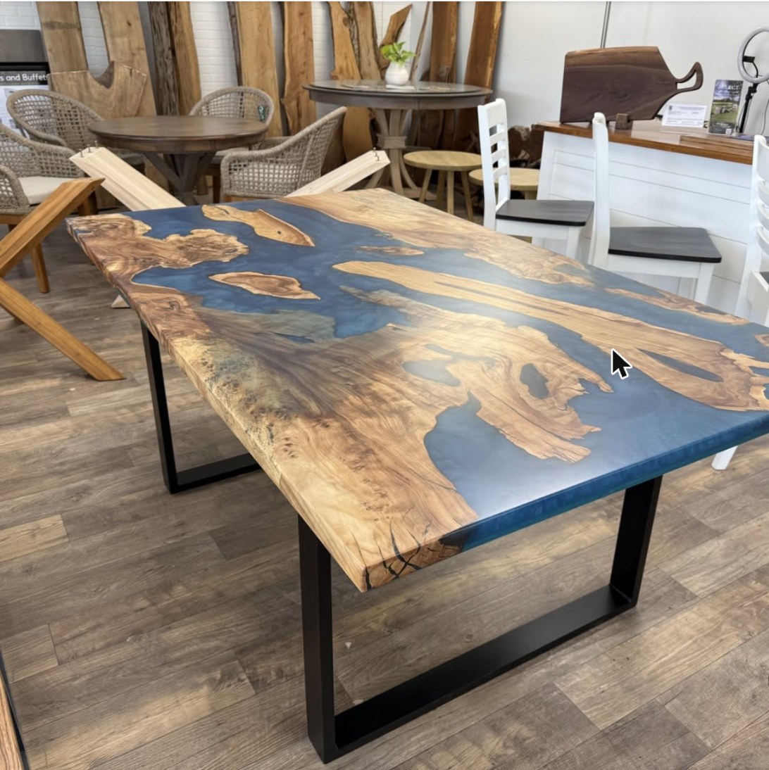 Blue epoxy river dining table on black steel base in the American Furniture and Design showroom